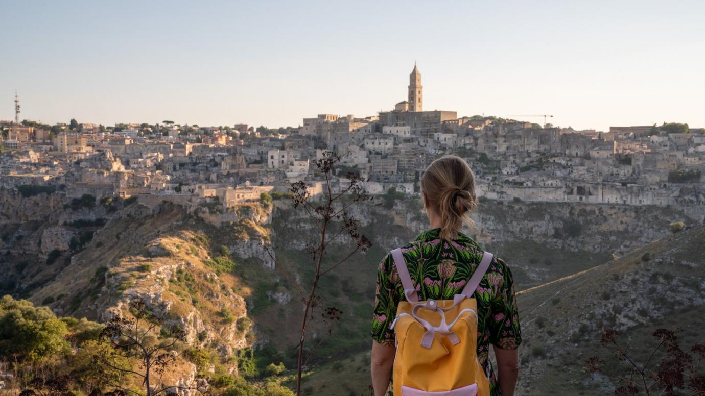 Woman with a backpack looking at a distant city