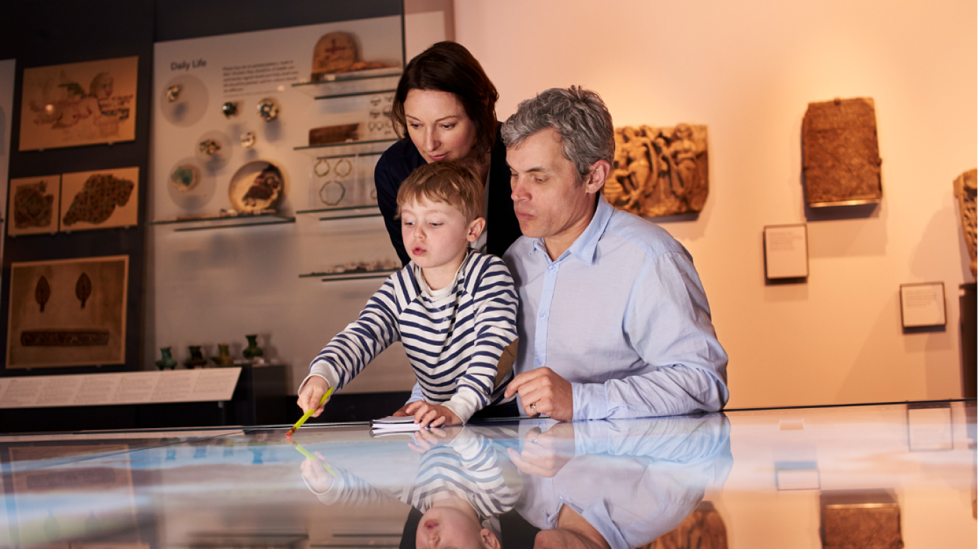 A family examining a collection in a museum