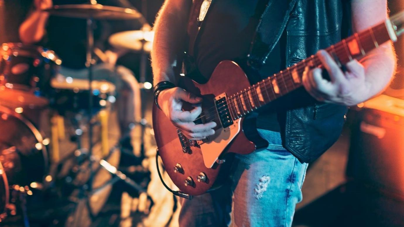 A close up of an electric guitar in a band